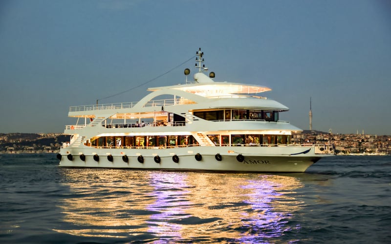 Our boat on the water at twilight with the city behind it