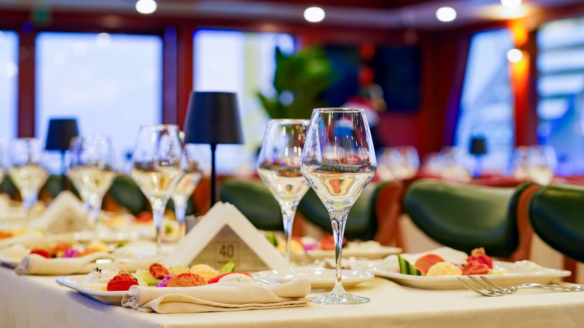 Laid tables in the enclosed dining salon before guests board