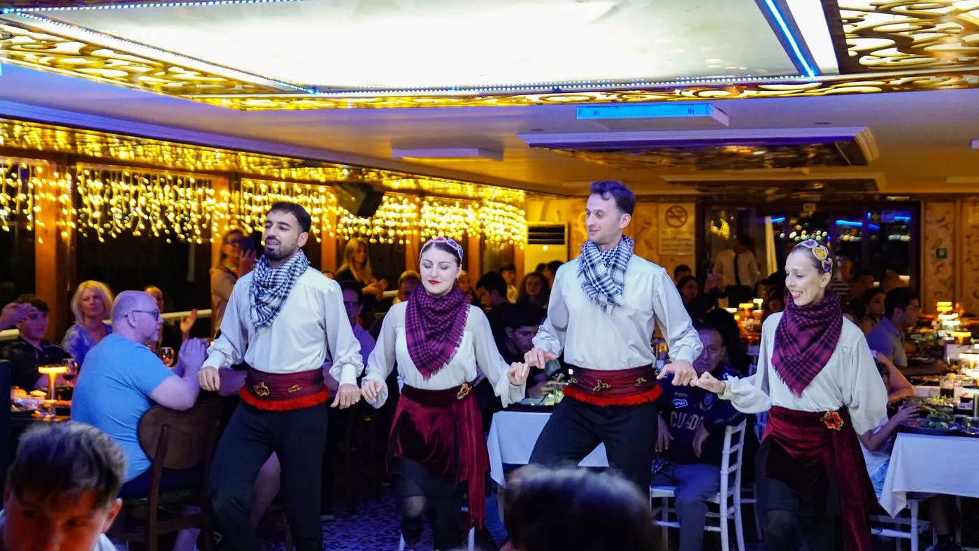 Folk dancers linked in a line between the tables