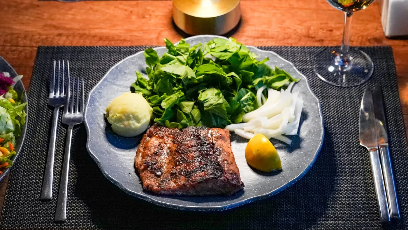 Grilled salmon with mashed potato, fresh greens and lemon