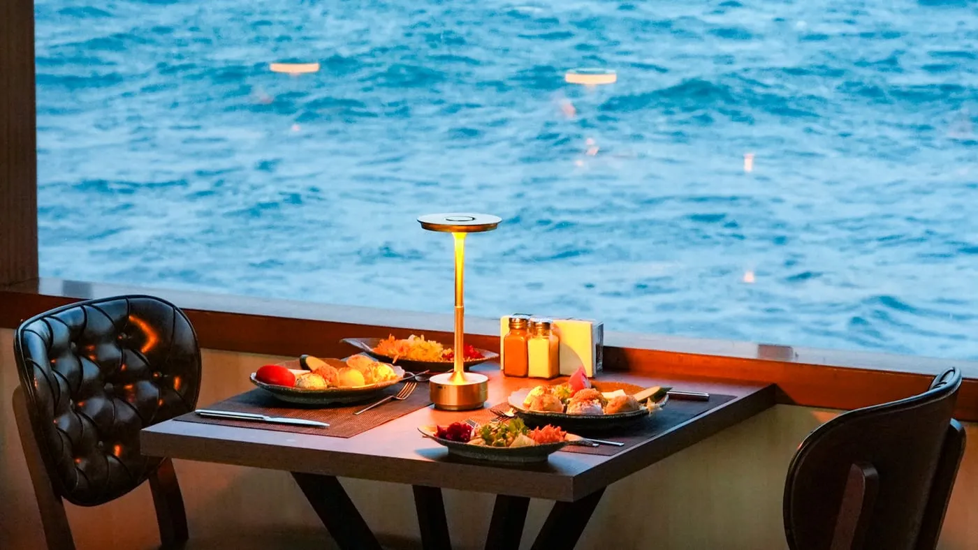 A window table laid with mezes, the water right outside the glass
