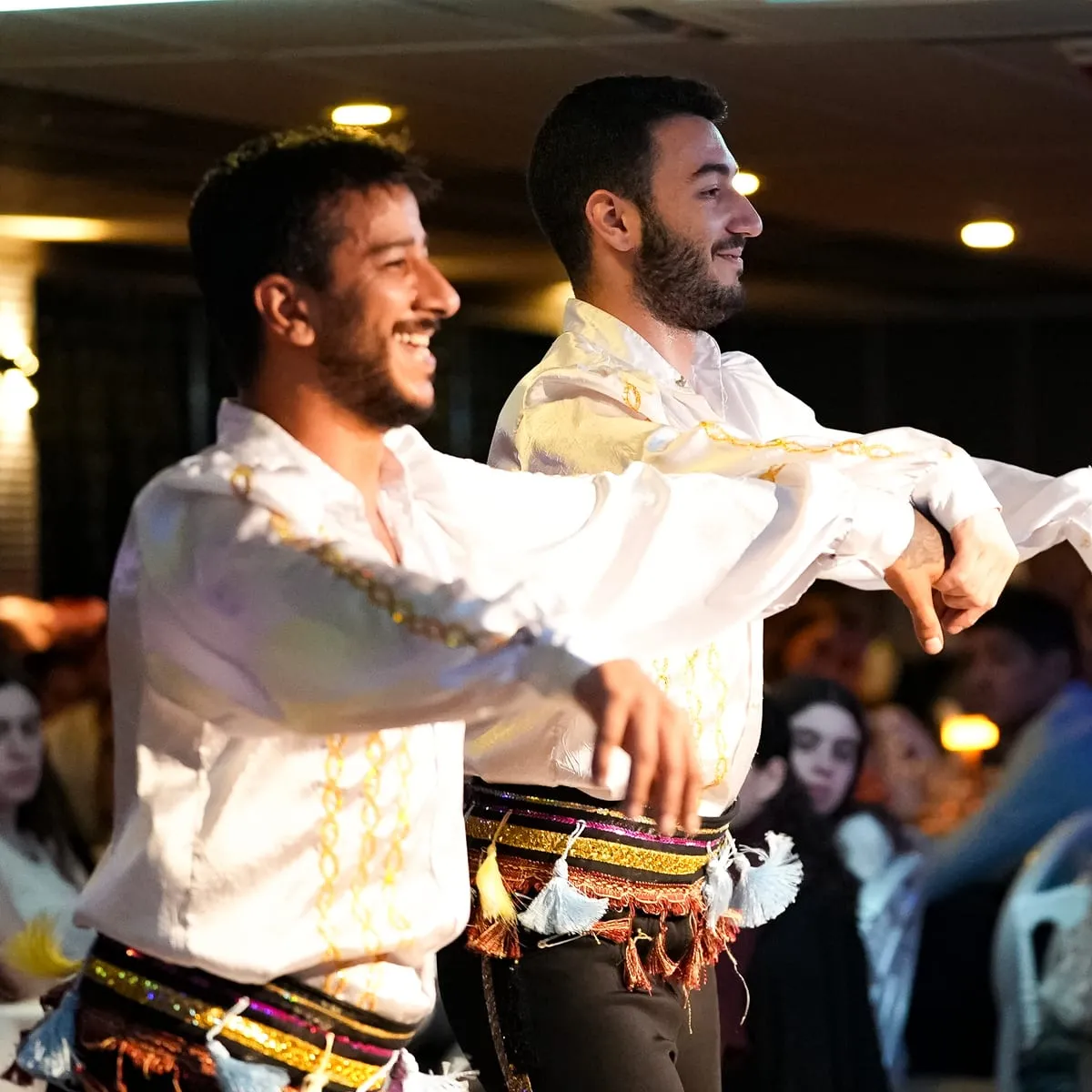 Two folk dancers in traditional costume among the guests