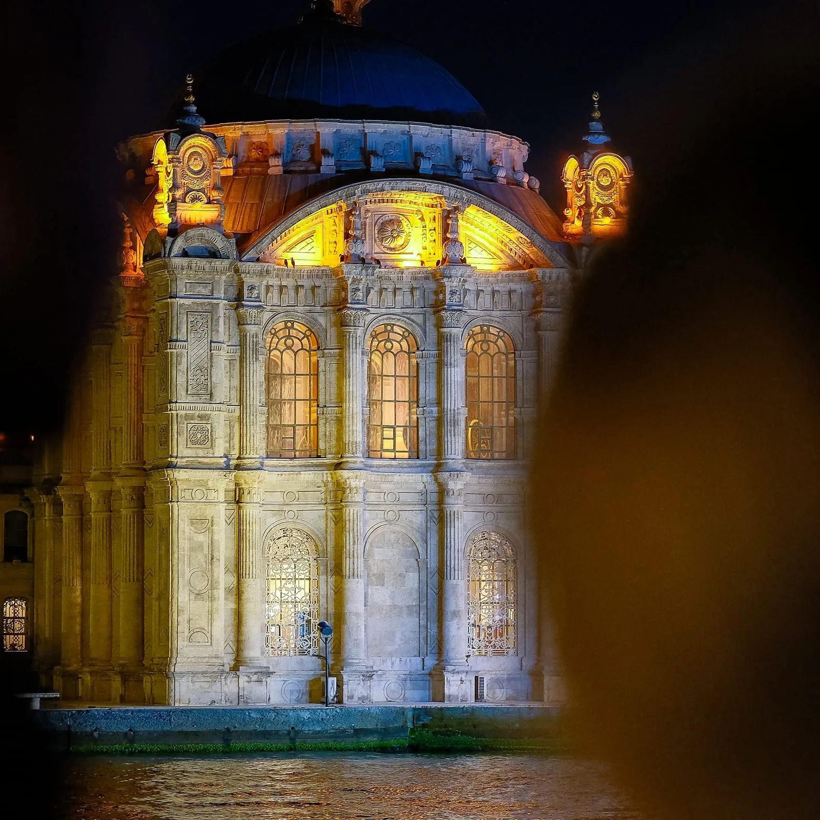 Ortaköy Mosque illuminated at night, seen from the boat