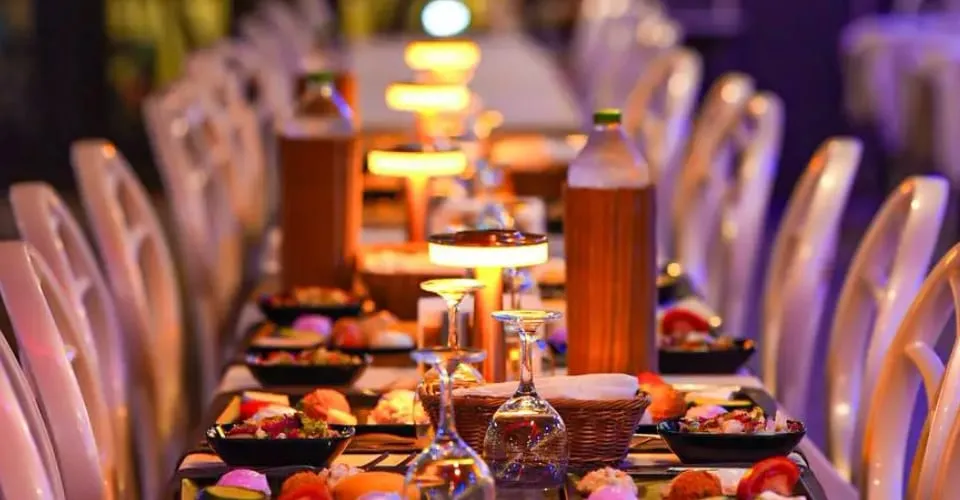 Tables laid for dinner with meze plates and table lamps